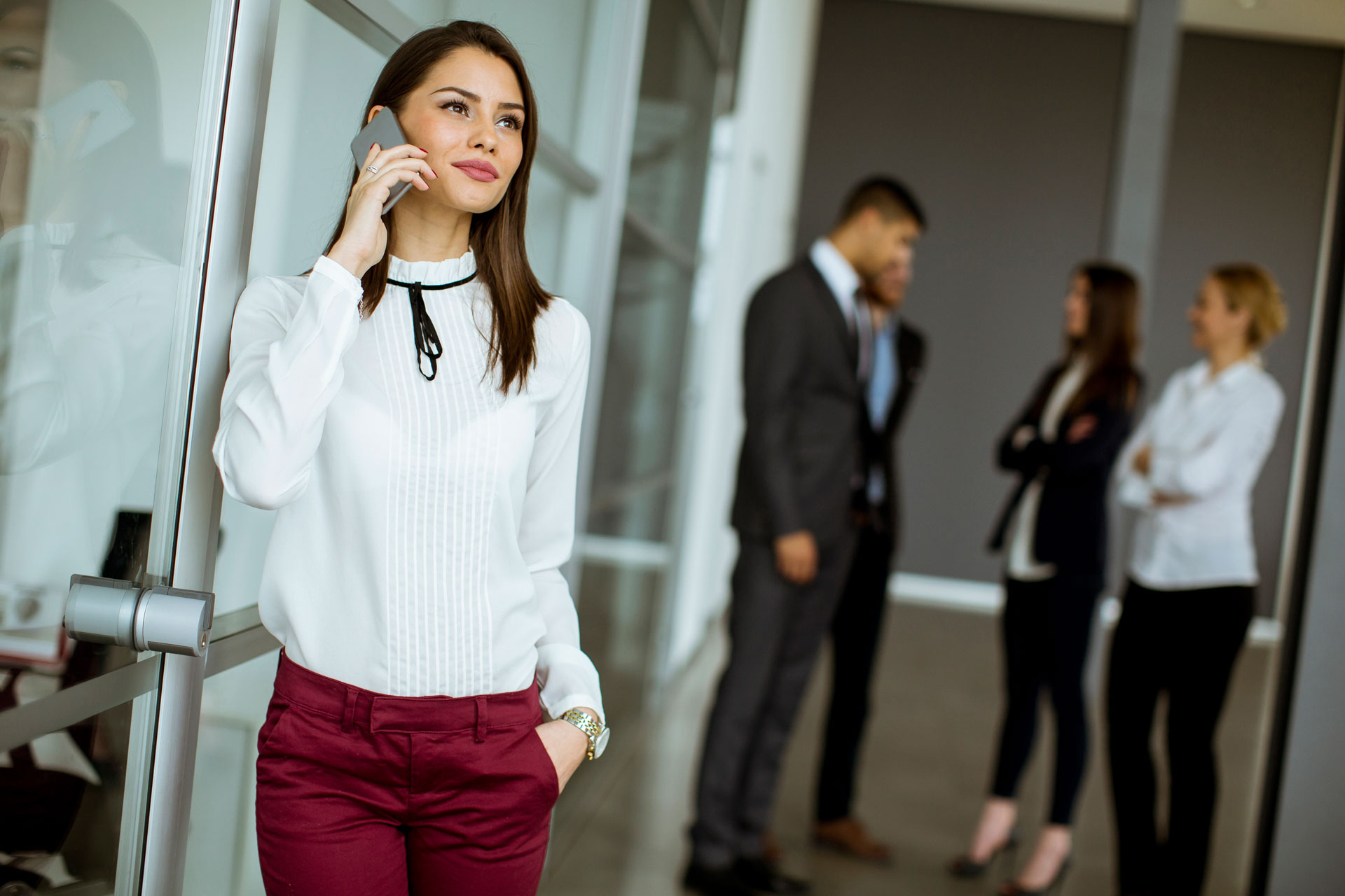 business woman talking on the phone with people in the background